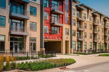 an apartment building with a red sign that reads parking  at Avant & Avant II, Carmel, Indiana